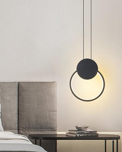 A circular, modern ceiling lamp hanging in a room over a desk