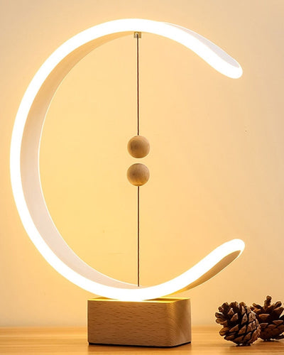 Magnetic Lamp with wooden base and two wooden spheres in a circular design and warm light