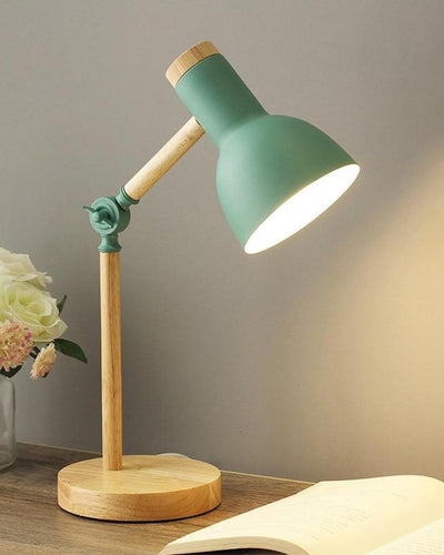 A classic wooden desk lamp with green color next to a book